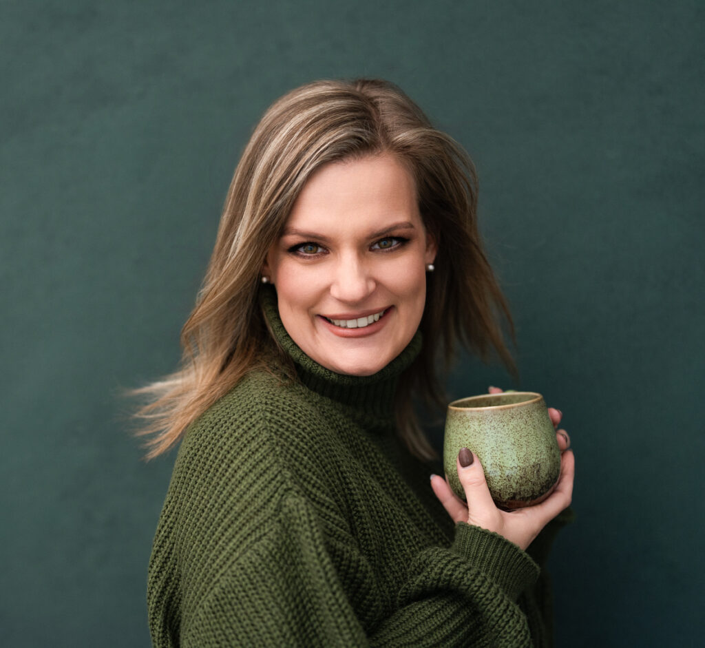 laura winterlich mit teetasse in der hand, lächelt in die kamera
